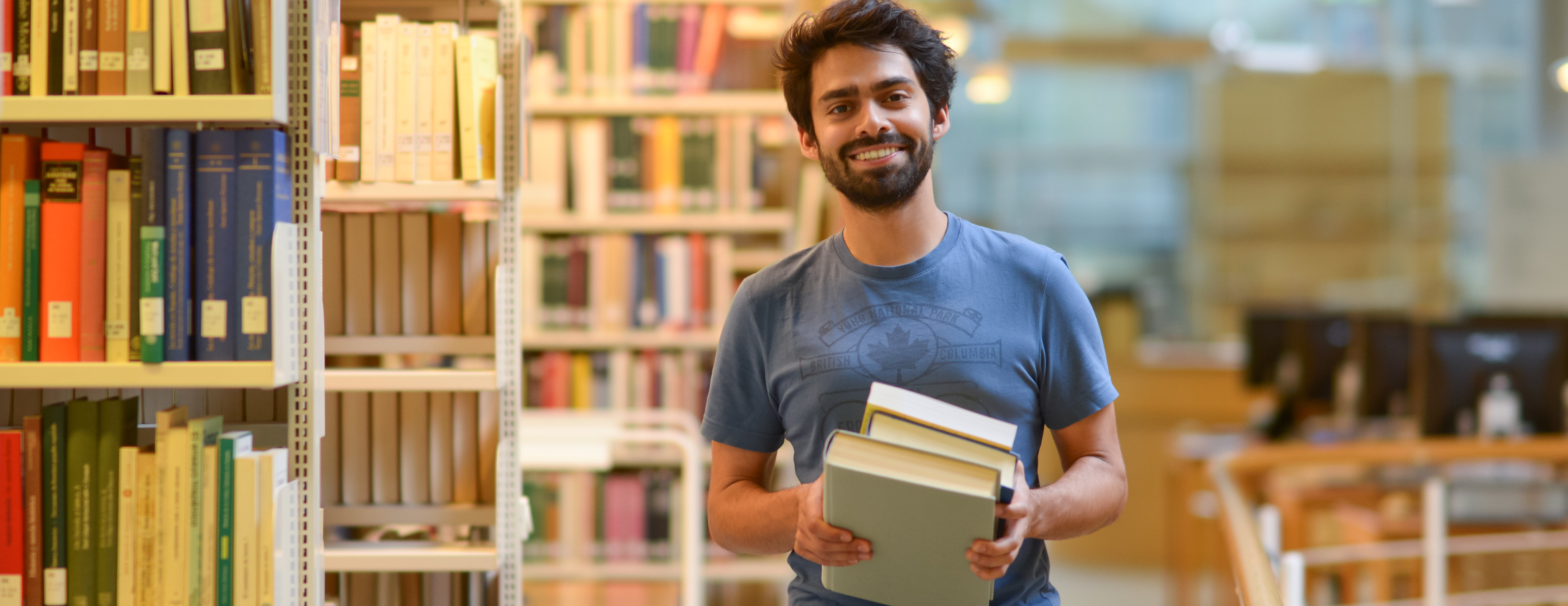 Zentralbibliothek: Leihen und Nutzen - Student mit Büchern