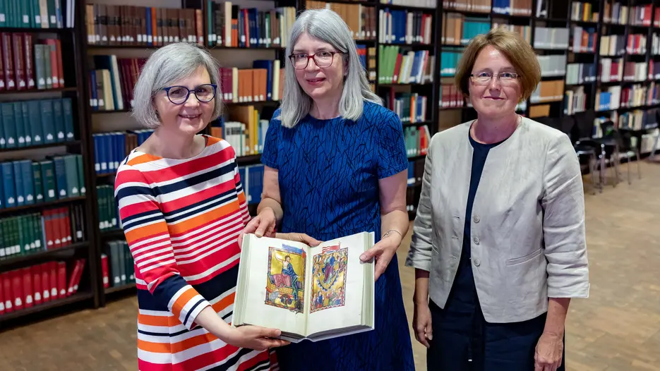 Die Direktorin der Staatsbibliothek Bamberg, Prof. Dr. Bettina Wagner (Mitte) überreicht eine Replik des Bamberger Psalter an die Leiterin der Universitätsbibliothek Eichstätt, Dr. Maria Löffler (links) sowie die Leiterin der Abteilung Historische Bestände, Dr. Heike Riedel.