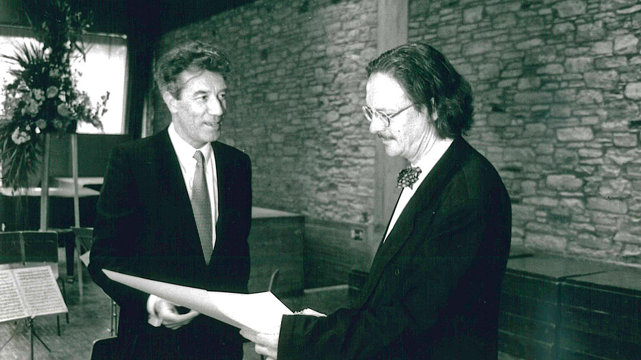 (v.l.) Der damalige Dekan der Sprach- und Literaturwissenschaftlichen Fakultät, Prof. Dr. Günter Niggl, verlieh 1993 Peter Handke die Ehrendoktorwürde. (Foto: upd)