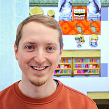 Dr. Dominik Engl – im Hintergrund ein Ausschnitt aus seinem mathematischen Computerspiel