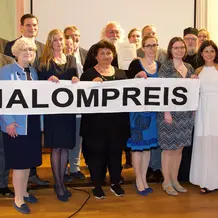 Preisträger Pfarrer Jozsef Lanko (Bildmitte mit Urkunde), links davor Agnes Jovanovic (Kindergartenleiterin im Projekt), Barbara Loos (Vorsitzende des Hochschulrates der KU; 3.v.l.),  Gerhard Rott (Leiter des Referates Weltkirche des Bistums Eichstätt; 2.v.l.), dahinter Burkhard Haneke (Geschäftsführer von Renovabis), daneben Schirmherr OB Andreas Steppberger. (Foto: AK Shalom)