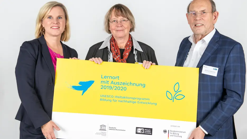 Dr. Catrin Hannken (Leiterin des Referats Bildung in Regionen, Bildung für nachhaltige Entwicklung im Bundesforschungsministerium) und Minister a.D. Walter Hirche (Internationaler Berater der Nationalen Plattform BNE und Vorsitzender des Fachausschusses Bildung der Deutschen UNESCO-Kommission) überreichten die Auszeichnung an die Nachhaltigkeitsbeauftragte der KU, Prof. Dr. Ingrid Hemmer (Mitte). (Foto: Deutsche UNESCO-Kommission/Thomas Müller)