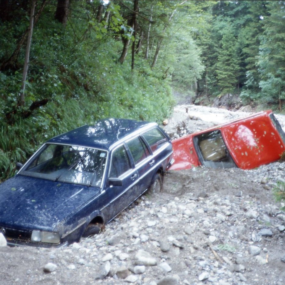 Photo, das Folgen des Ereignisses von 1990 zeigt (zusammengeschobene und eingeschotterte Autos)