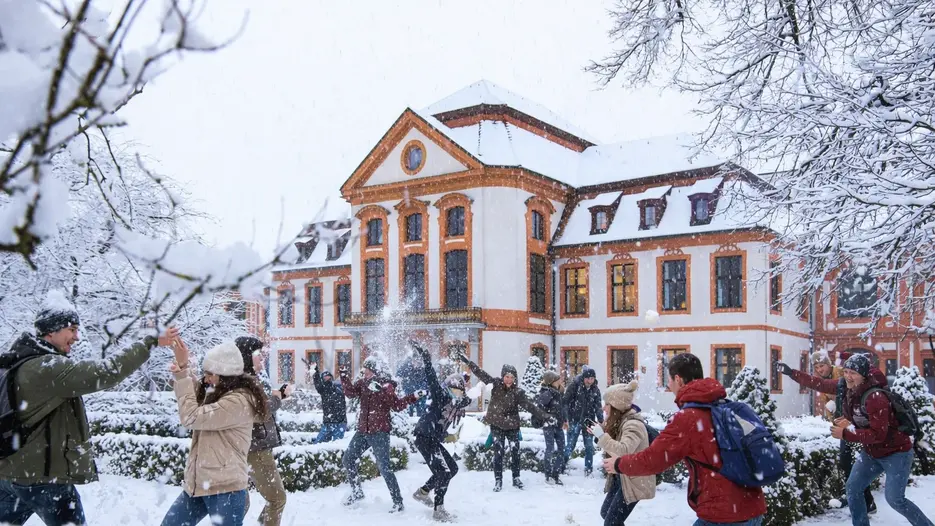 Mit KI erstelltes Foto: Studierende machen eine Schneeballschlacht vor der Sommerresidenz