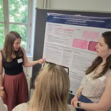 Studierende erkl&auml;rt ein wissenschaftliches Poster