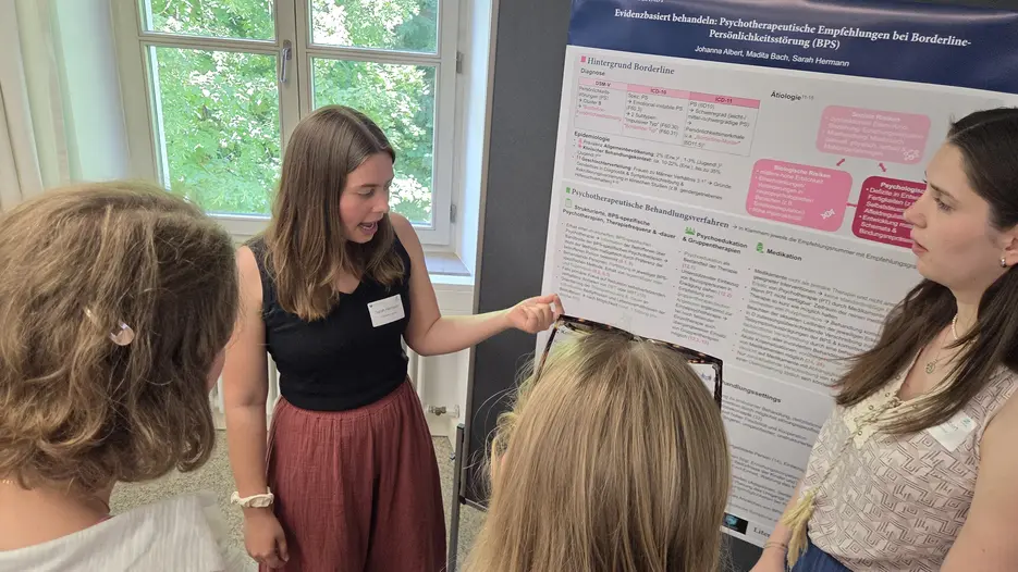 Studierende erkl&auml;rt ein wissenschaftliches Poster