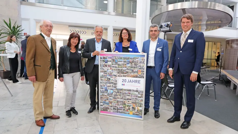 Lehrstuhlinhaber Prof. Dr. Harald Pechlaner (3.v.l.) und Uni-Präsidentin Prof. Dr. Gabriele Gien (4.v.l.) zusammen mit (v.l.) Karl Jägle, Bürgermeisterin Elisabeth Gabler, Landrat Alexander Anetsberger und Dirk Glaesser (Welttourismusorganisation UNWTO) versammelt um eine Collage mit Impressionen aus 20 Jahren Lehrstuhl Tourismus.