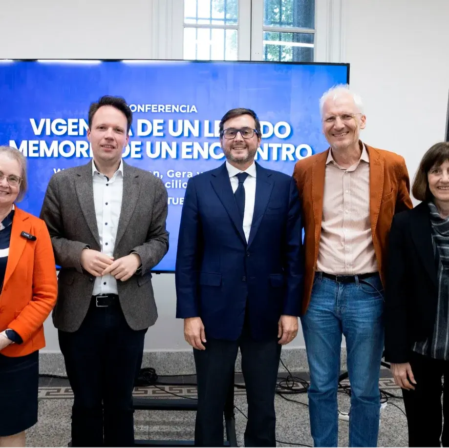 Gruppenfoto vor Leinwand, links Kreuz und Marienstatue