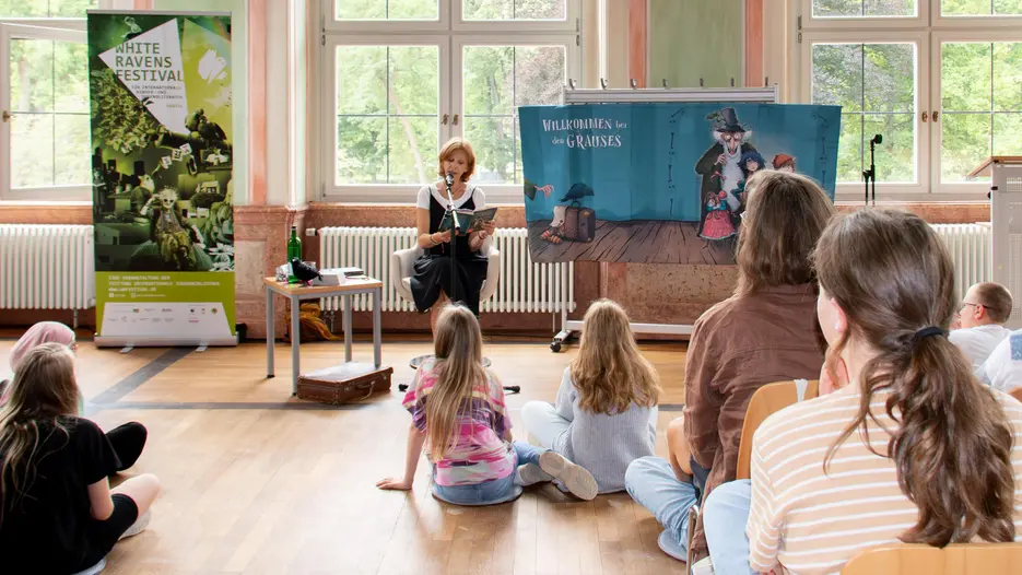 Sabine Bohlmann liest vor einer Gruppe von Kindern