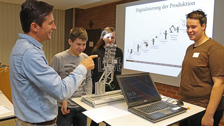 Dr. Michael Köck erläuterte den Schülerinnen und Schülern die Funktionsweise einer künstlichen Hand, die es mit Hilfe einer Konstruktionssoftware und eines 3D-Druckers zu optimieren galt. (Foto: Schulte Strat-haus/upd)