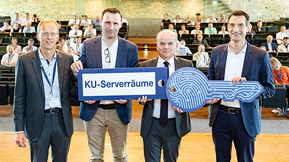 Dr. Rolf-Dieter Jungk, Head of the Bavarian Ministry for Science and Arts symbolically handing the key to the new server rooms to Nils Blümer (left), Head of the Computer Center at the KU, Stefan Wenzel (Head of construction and technical facility management) and Vice President Prof. Dr. Jens Hogreve