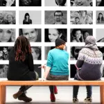 Icon Studium, 3 Personen vor Wand mit Gesichtern