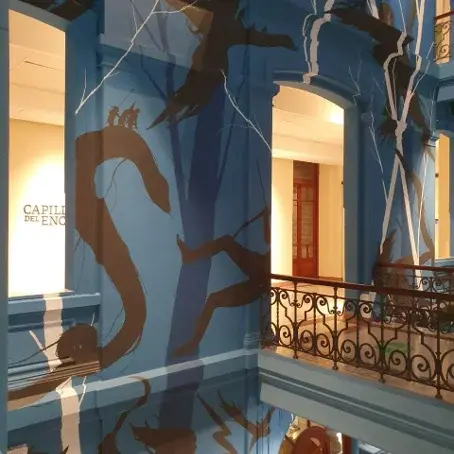 Treppenhaus der Katholischen Universität von Uruguay: Erkennbar ist eine Schlange und andere Tiere sowie ein Mensch, der sich im Fallen befindet, im Hintergrund ein Baum.