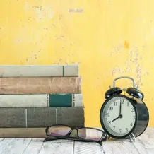 Bücherstapel neben einem Wecker