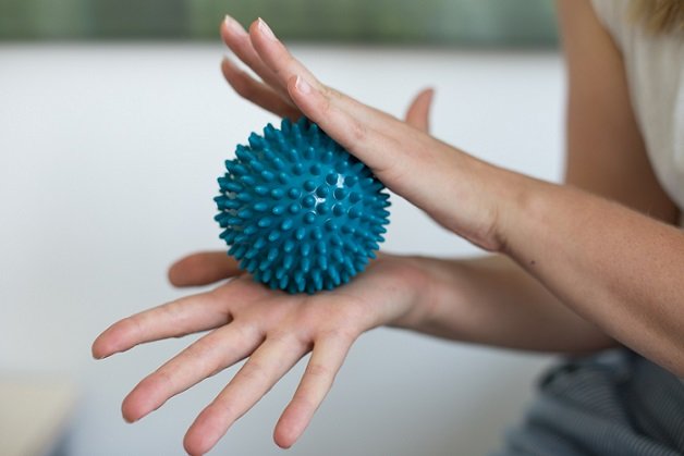 Massage-/Stressball wird in Hand gehalten