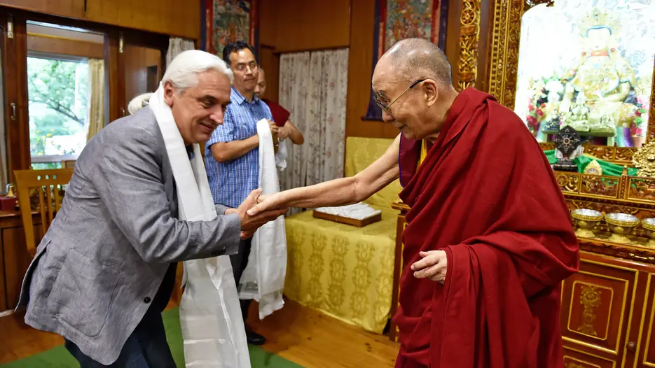 Bildinformation „Dalai Lama1“: Prof. Dr. Krassimir Stojanov (links) wurde vom Dalai Lama bei internationalen Treffen von Bildungsphilosophen und Bildungssoziologen im indischen Dhramsala begrüßt. (Foto: Office of HH the DL)