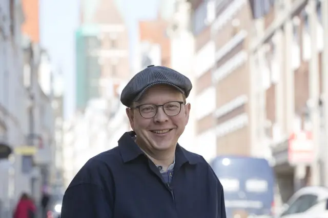 Martin Gries, ein freundlich lächelnder Mann mit Schirmmütze und Brille