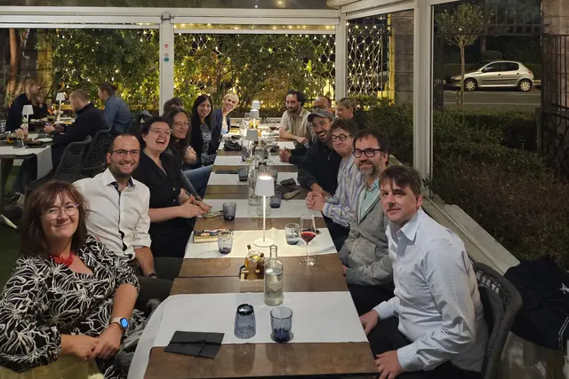 Die Teilnehmenden des Workshops sitzen abends an einer langen Tafel auf einer beleuchteten Restaurantterrasse.