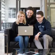 Studierende schauen gemeinsam in einen Laptop