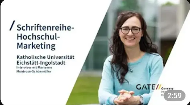 Eine dunkelhaarige Frau mit Brille und hellblauem Shirt