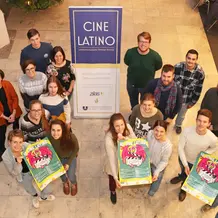 Das Organisationsteam hinter dem Cine Latino mit dem diesjährigen Jubliäumsplakat. (Foto: Schulte Strathaus/upd)