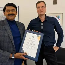 Prof. Dr. Shashi Matta h&auml;lt die Urkunde des WFI Highlight in den H&auml;nden, neben ihm Dekan Prof. Dr. Thomas M&auml;hlmann.