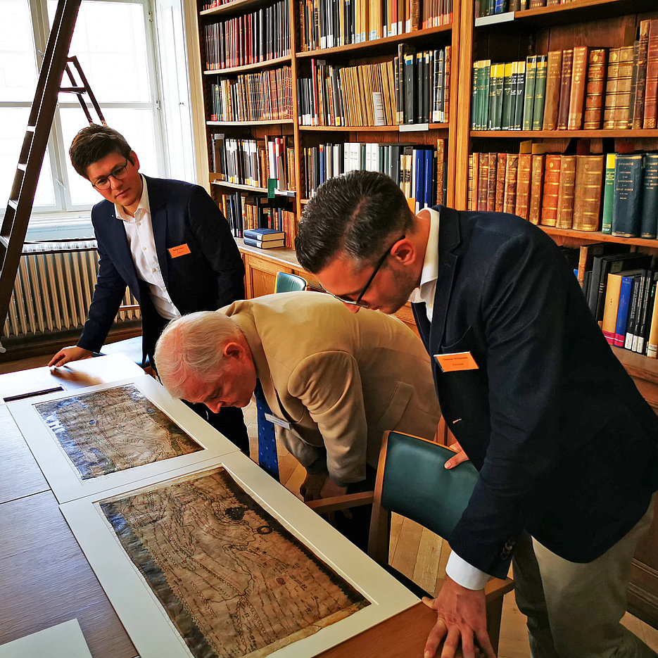Philipp Köhner (left) and Thomas Wittmann (right) from the KU Chair of Ancient History examining parts of the original Tabula Peutingeriana together with Prof. Dr. Richard Talbert (Chapel Hill, USA). (Photo: Bernhard Hübner)